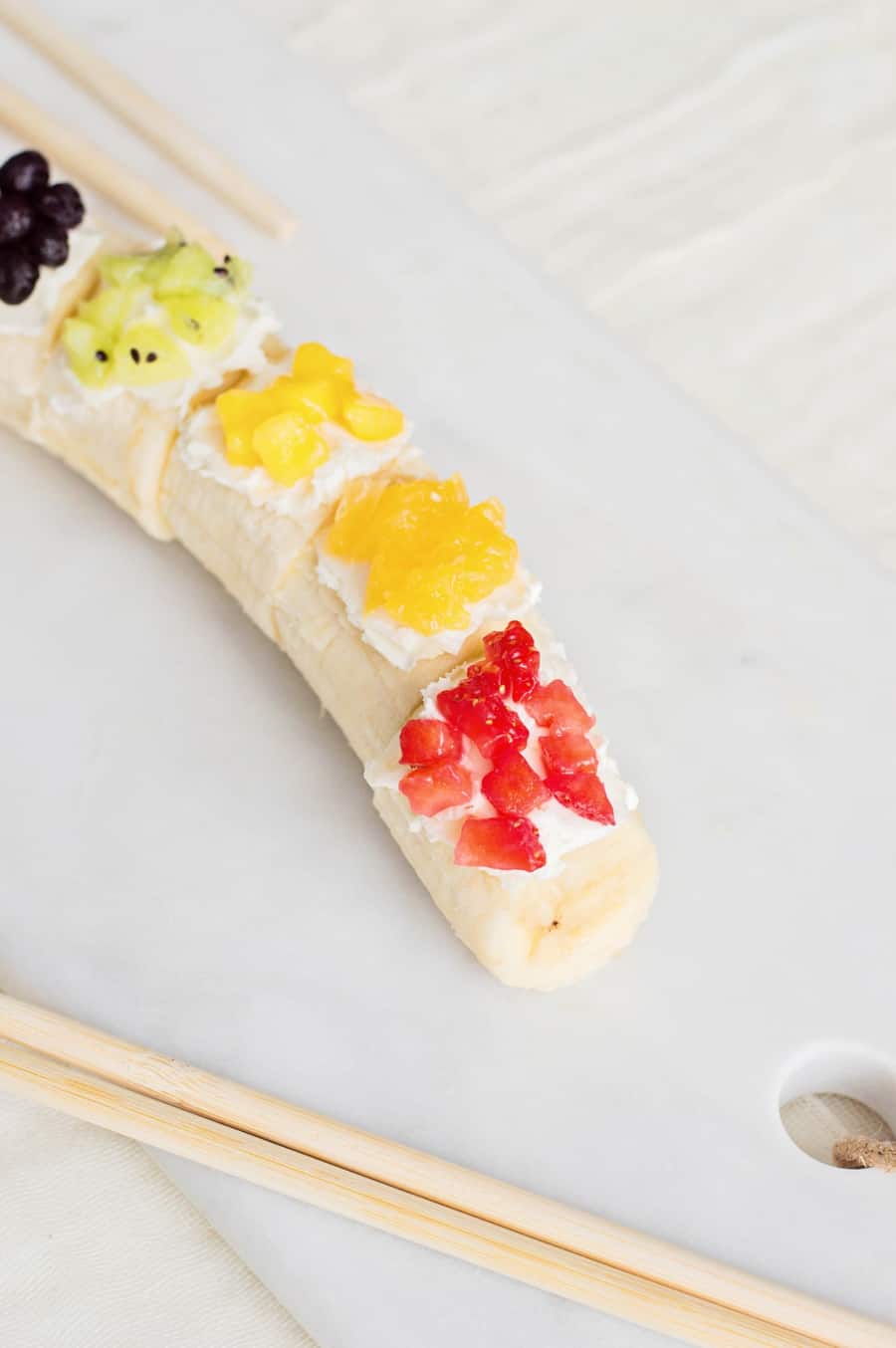 Kids will love getting a healthy, vitamin-packed start to their day with this rainbow fruit banana sushi - a fun snack featuring fresh fruit!