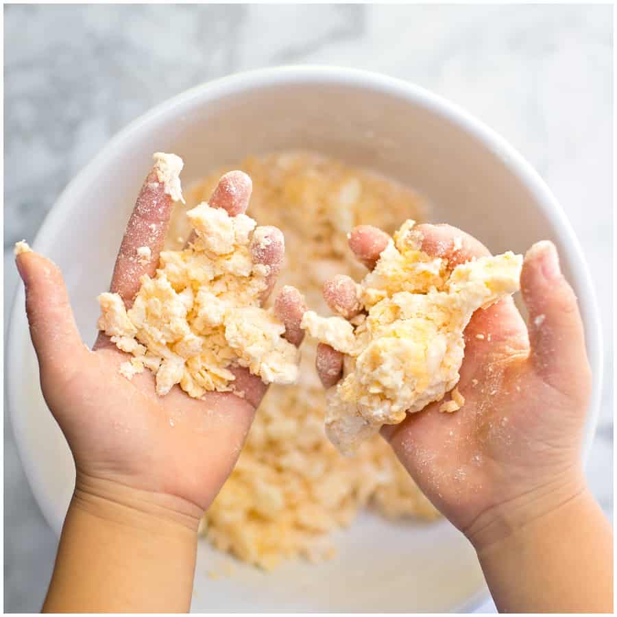 kids hands in cracker dough kneading the dough for cheese animal crackers