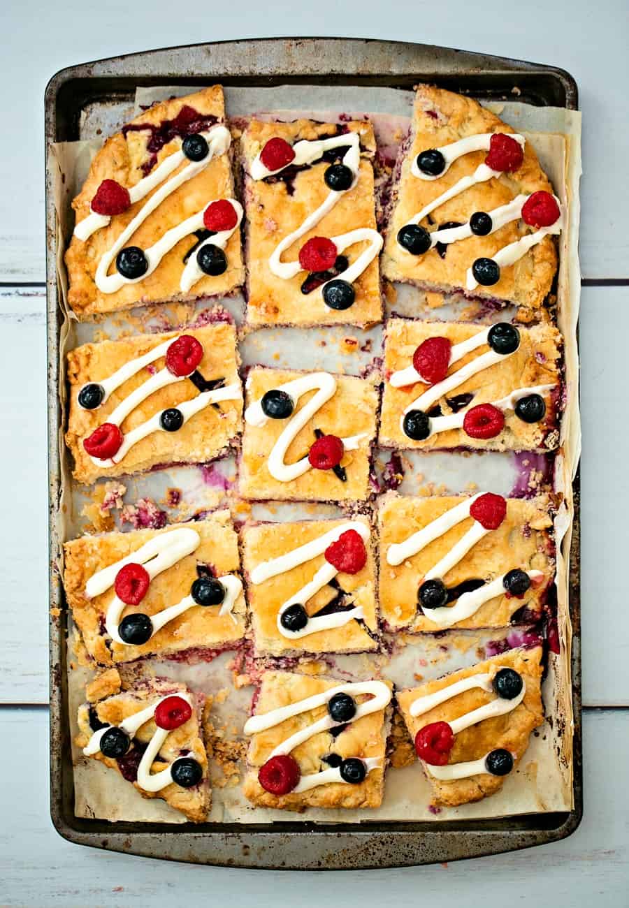 Raspberry Blueberry Slab Pie with a cream cheese frosting drizzle garnished with fresh berries. Delicious and easy patriotic dessert for Memorial Day or Fourth of July. 