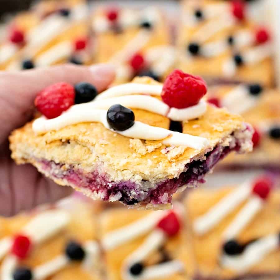 Raspberry Blueberry Slab Pie with a cream cheese frosting drizzle garnished with fresh berries. Delicious and easy patriotic dessert for Memorial Day or Fourth of July. 