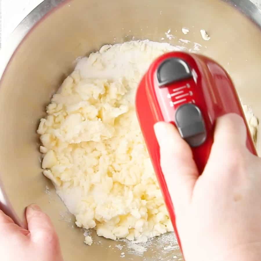 Creaming butter and sugar with a hand mixer to make soft vanilla sugar cookies