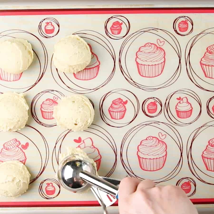 Piping mounds of cookie dough to make Soft Baked Frosted Vanilla Sugar Cookie Recipe