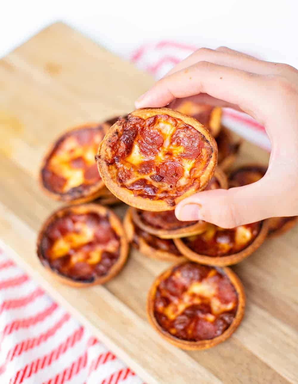 Muffin tin pizza one hand holding one