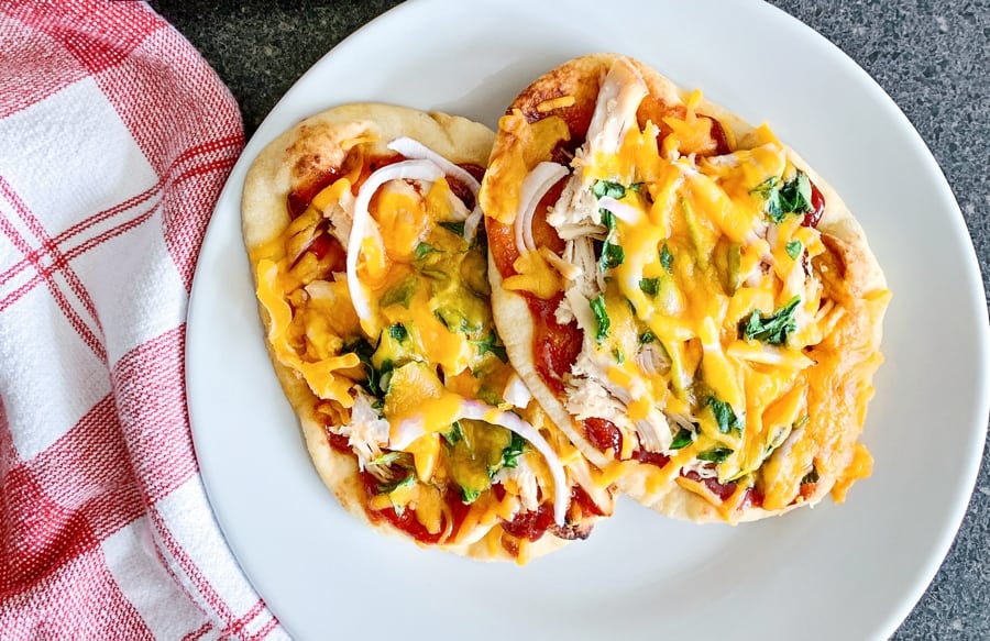 shredded cheese on top of naan bbq chicken 