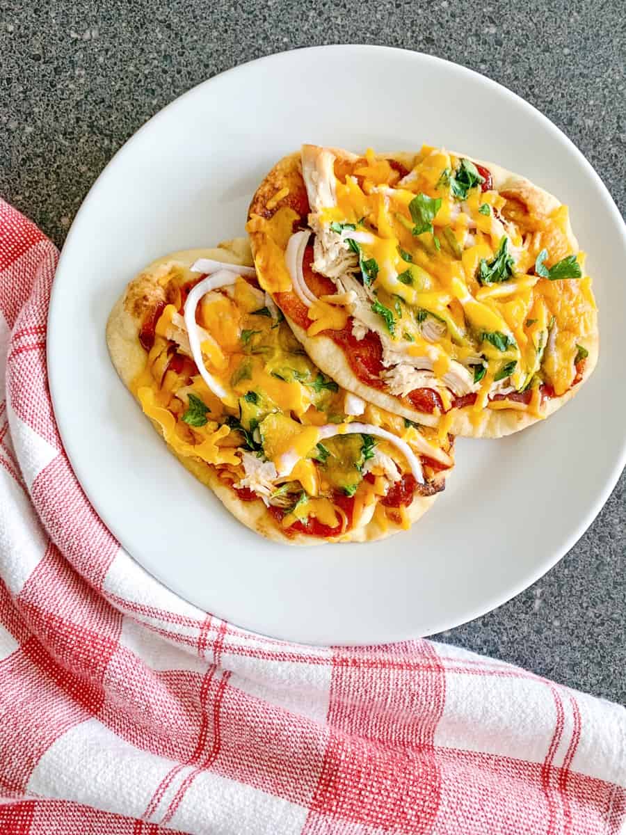 BBQ Chicken Naan Pizzas with red checkered dish cloth on counter