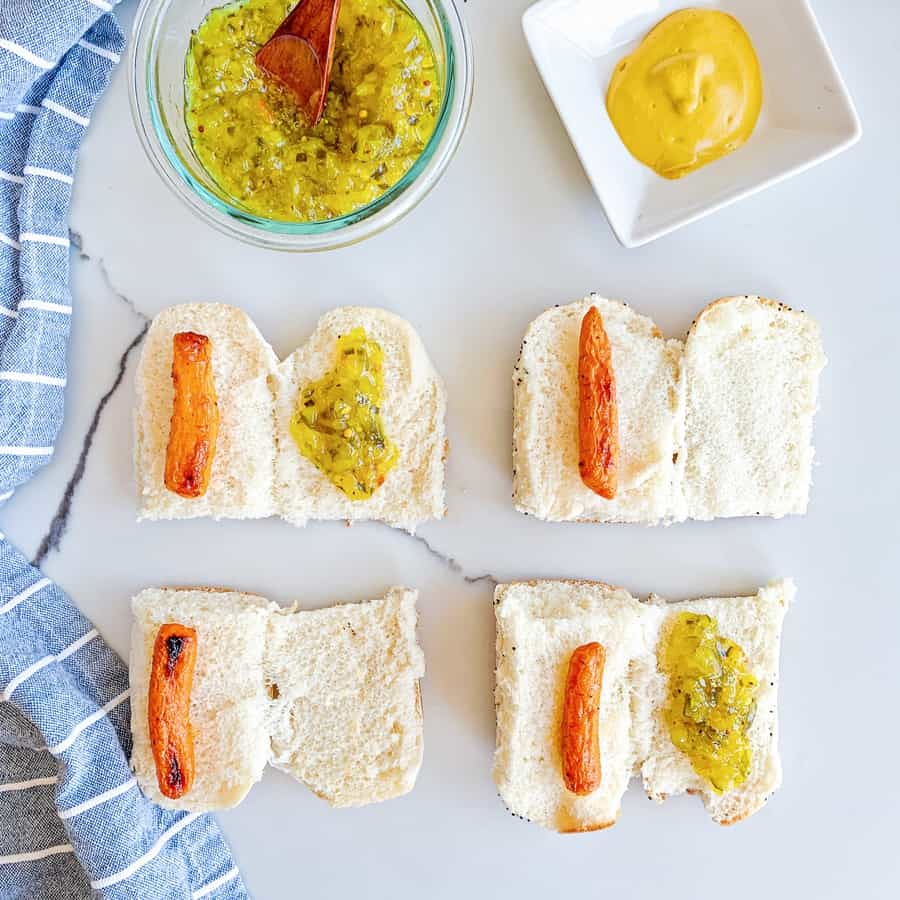 sliced hot dog buns in half with carrots inside and relish