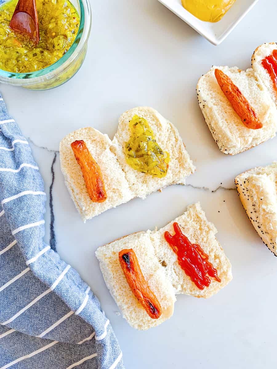 sliced hot dog buns in half with carrots inside and relish