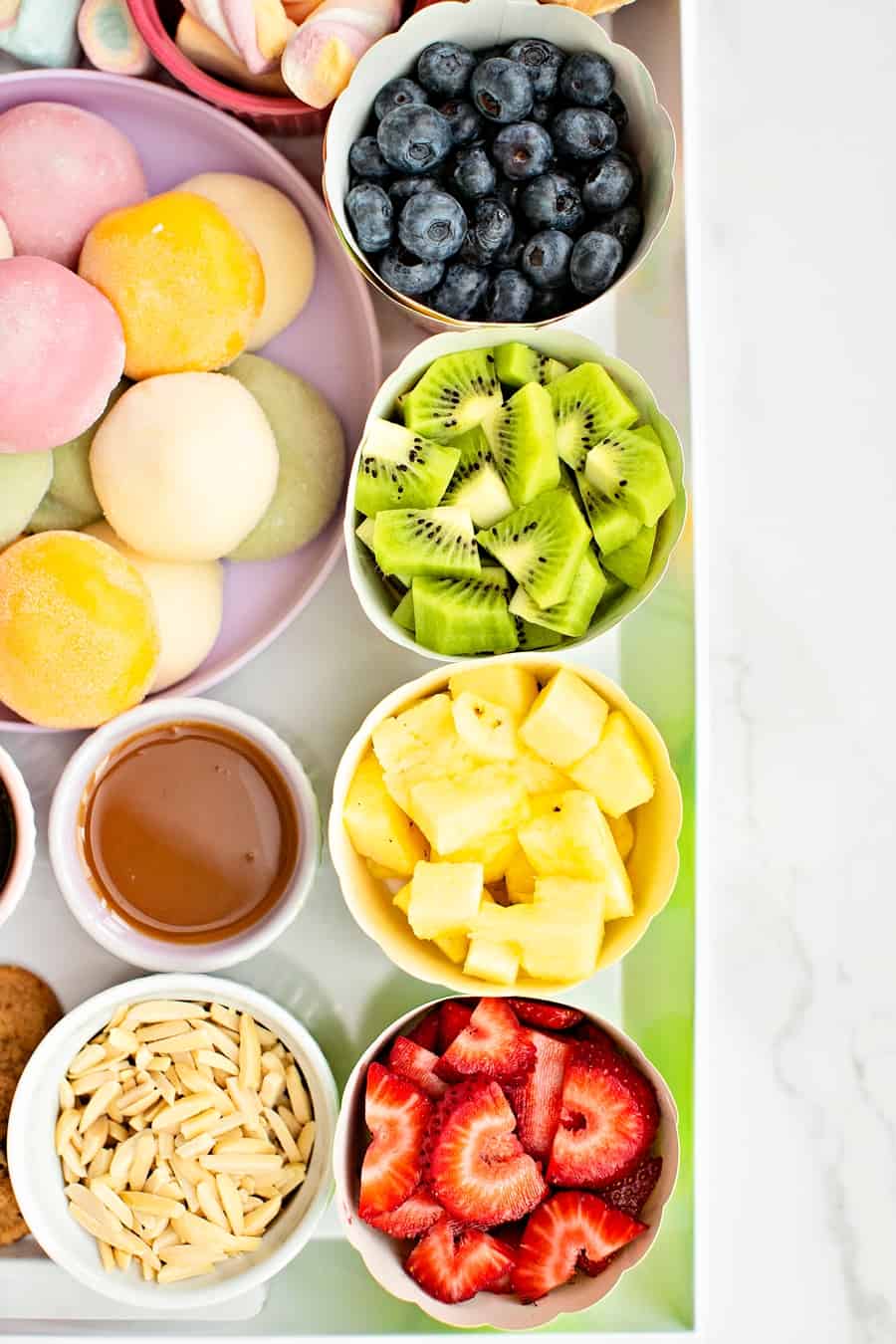 bowls of fruit blueberries, kiwi, pineapple and strawberries up up close