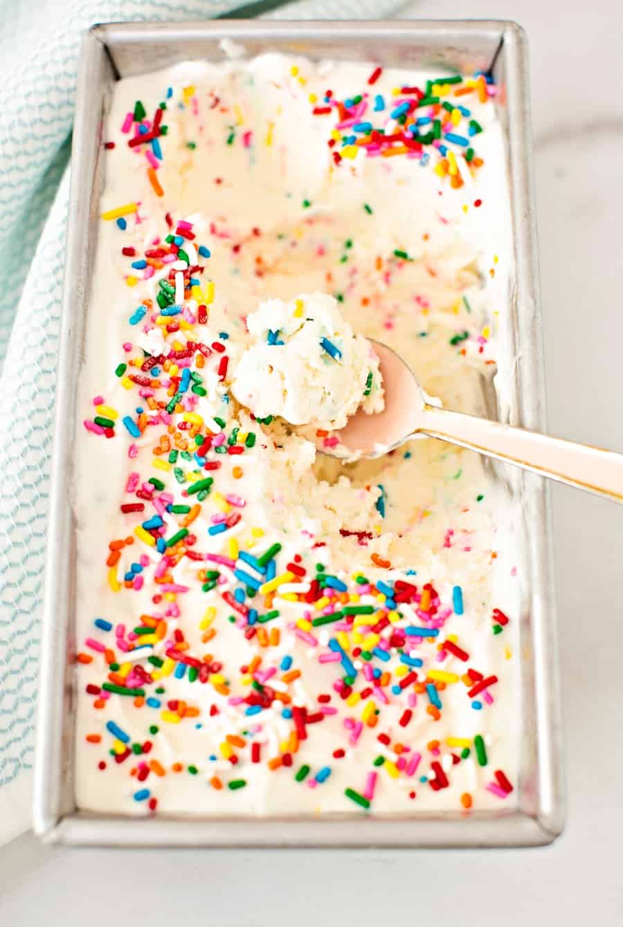 a spoon inside no churn ice cream with sprinkles on top