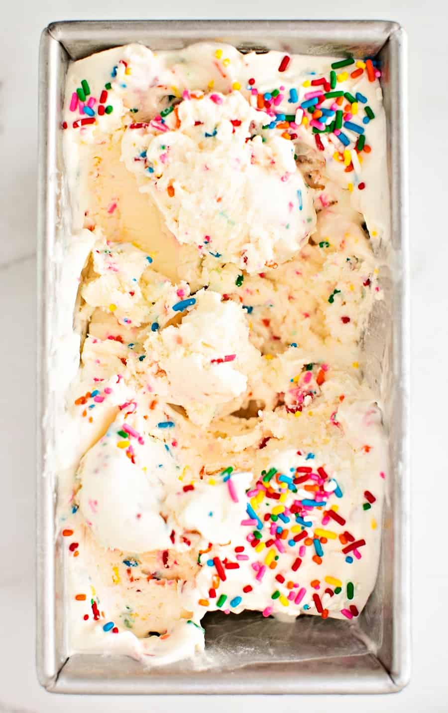 homemade 3 ingredient sprinkles ice cream inside a loaf pan 