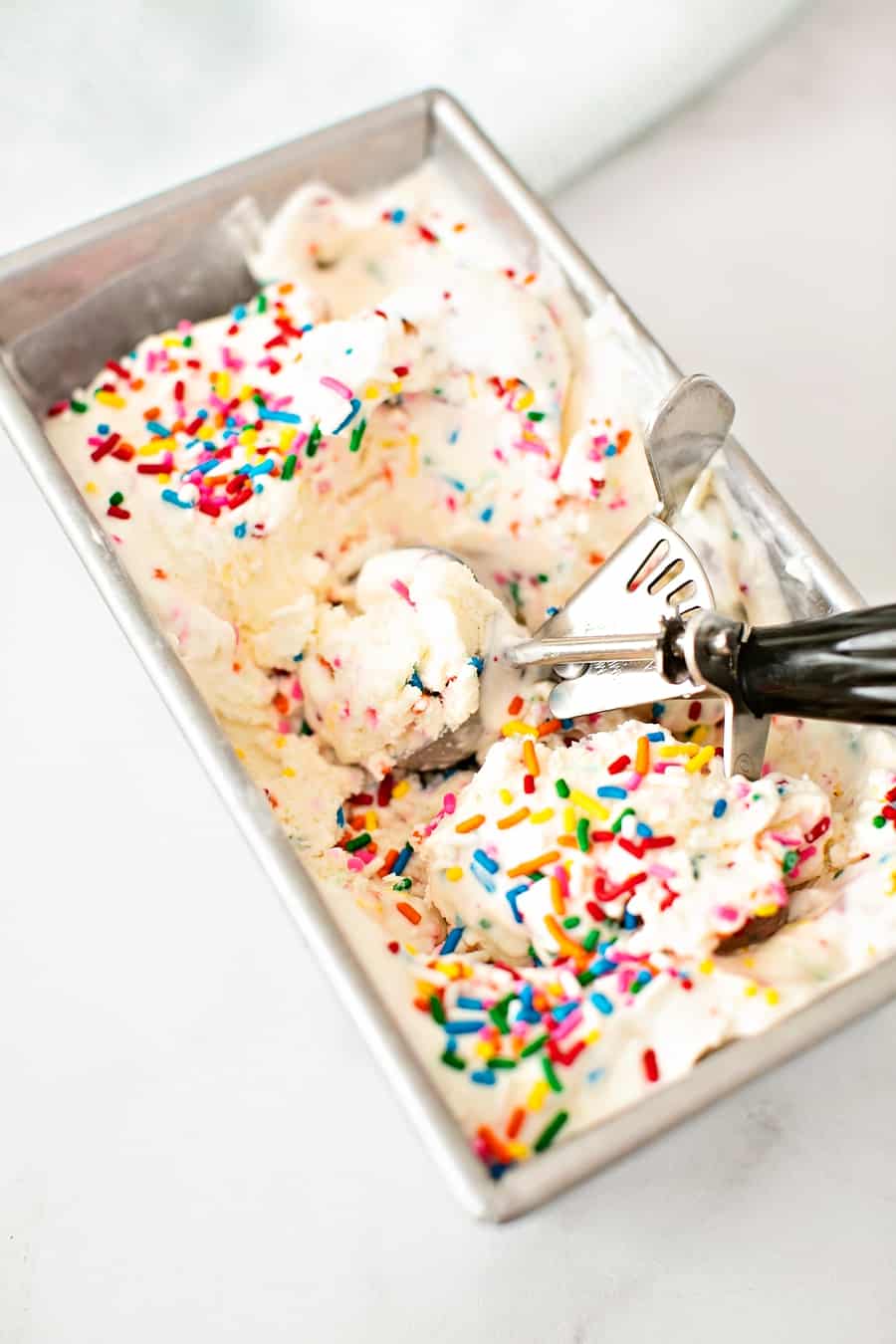 ice cream scoop inside a pan of homemade ice cream