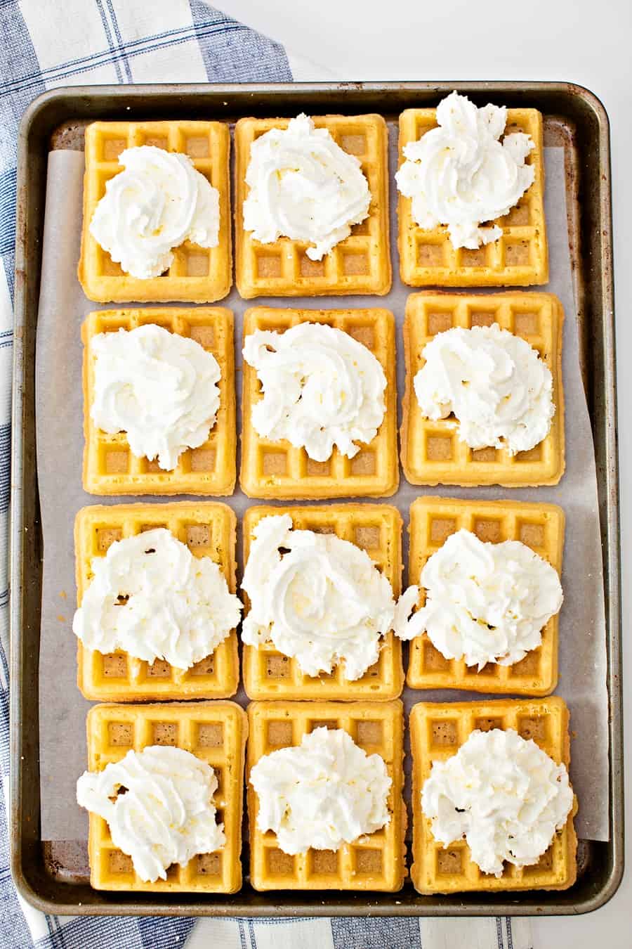 waffles on a sheet pan with whipped cream on top