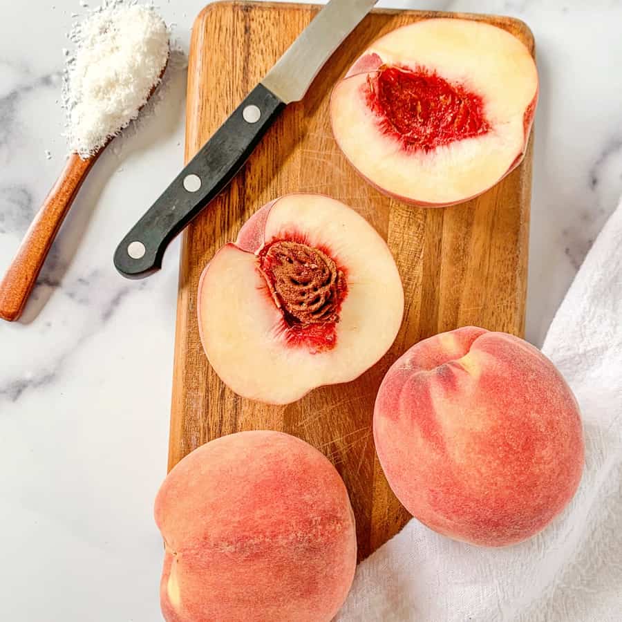 cut peaches on a wooden cutting board