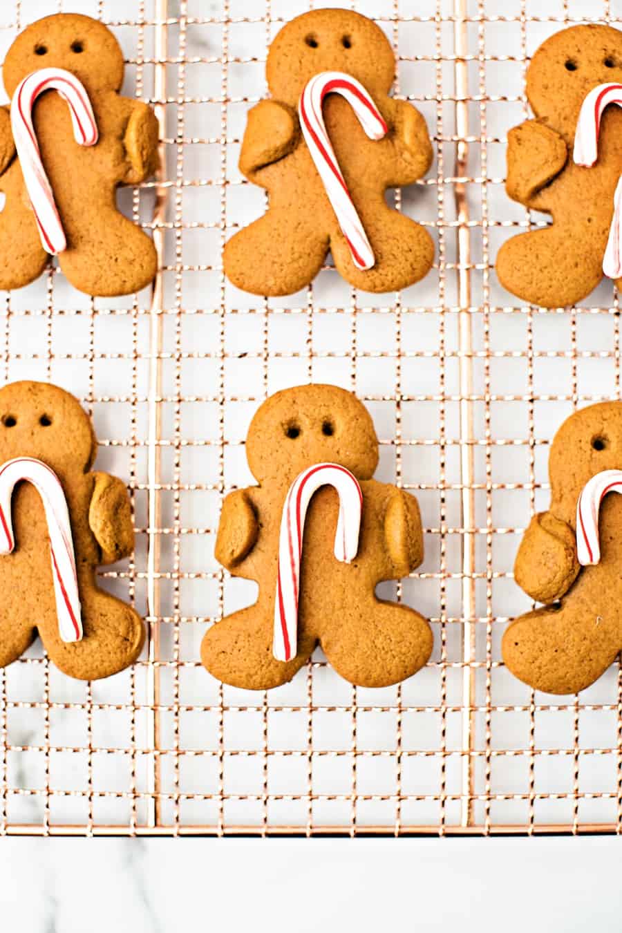 Gingerbread men cookies holding candy canes