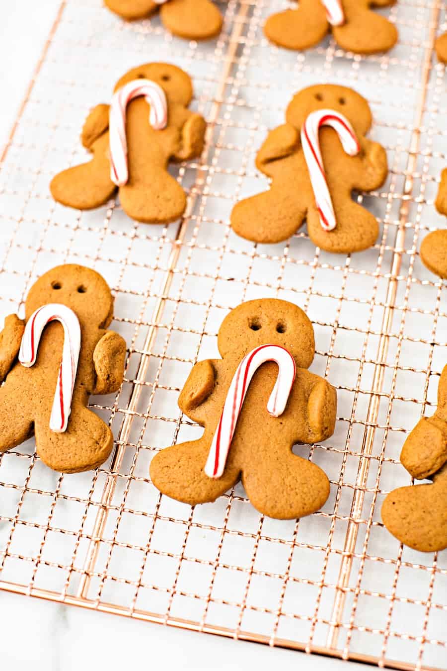 Gingerbread men cookies holding candy canes