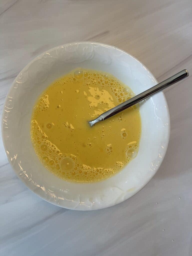 egg mixture mixed up in white bowl with spoon